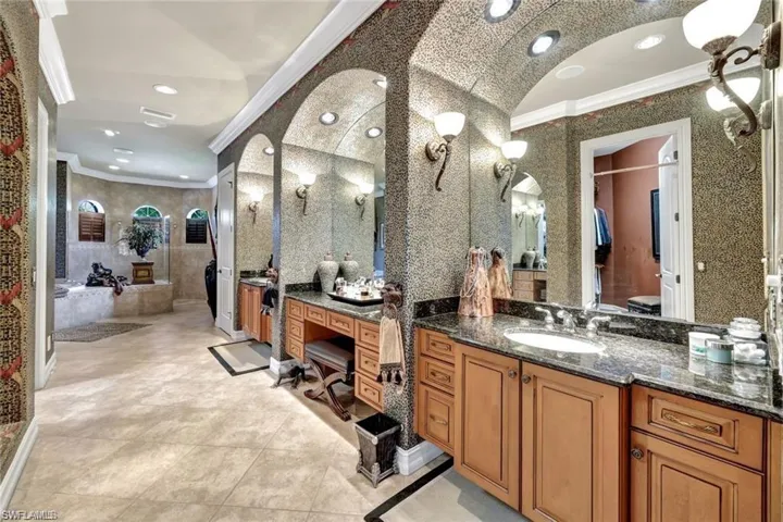 Bathroom with a bathing tub, tile patterned flooring, lofted ceiling, vanity, and ornamental molding