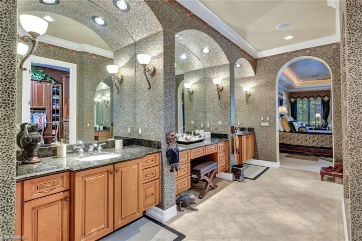 Bathroom with vanity, lofted ceiling, and ornamental molding