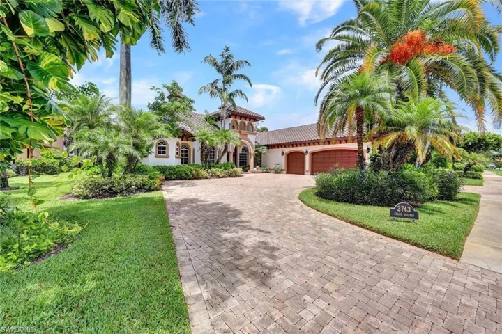 Mediterranean / spanish-style home featuring a front yard and a garage