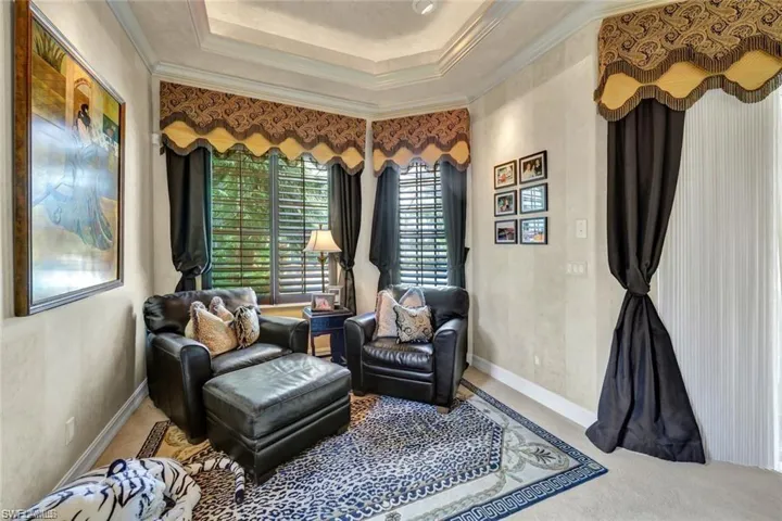 Living area with a tray ceiling and crown molding