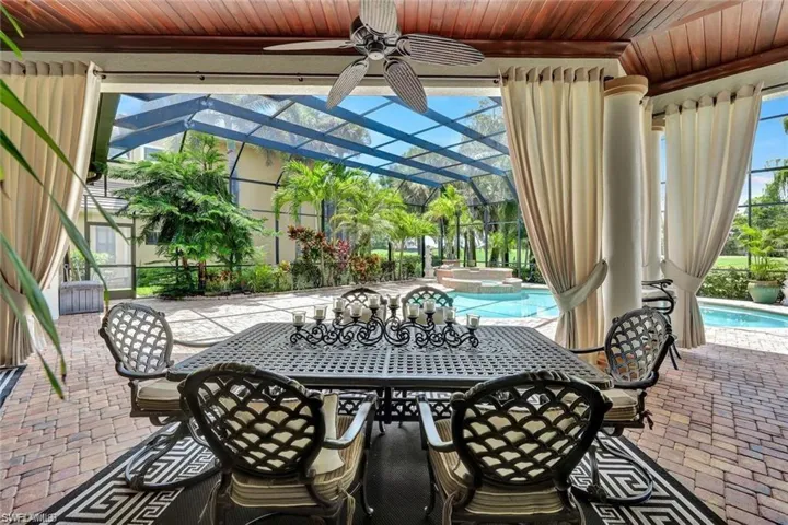 View of patio with ceiling fan and a lanai