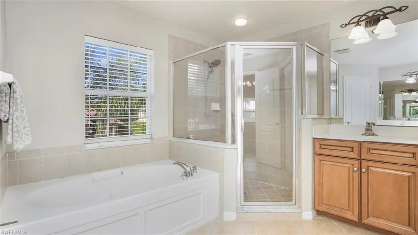 Bathroom with vanity, a bath, a stall shower, and tile patterned floors