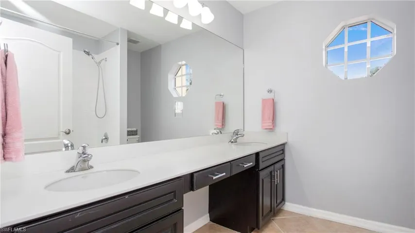 Bathroom featuring double vanity, tile patterned flooring, and shower / bathtub combination