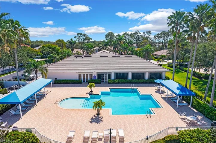 Community pool featuring french doors, a patio area, and view of wooded area