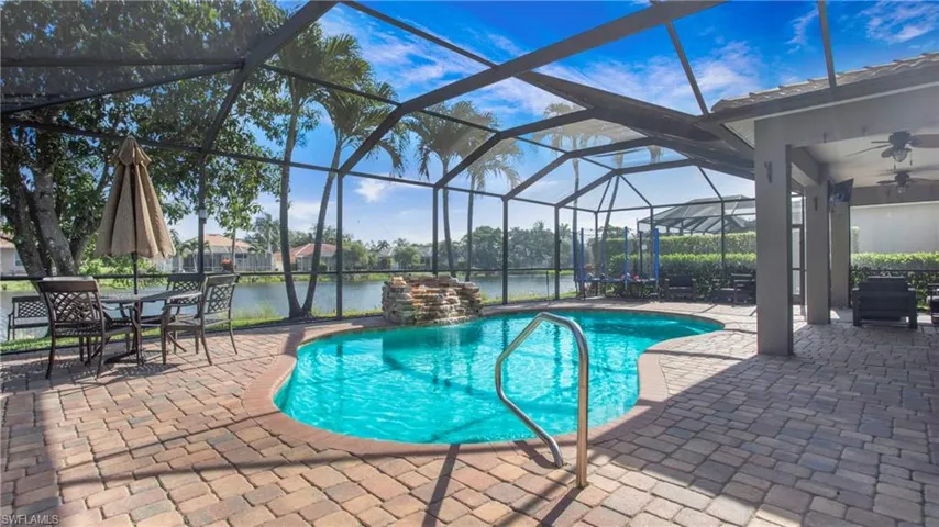 Outdoor pool featuring a patio area, ceiling fan, a water view, and a lanai