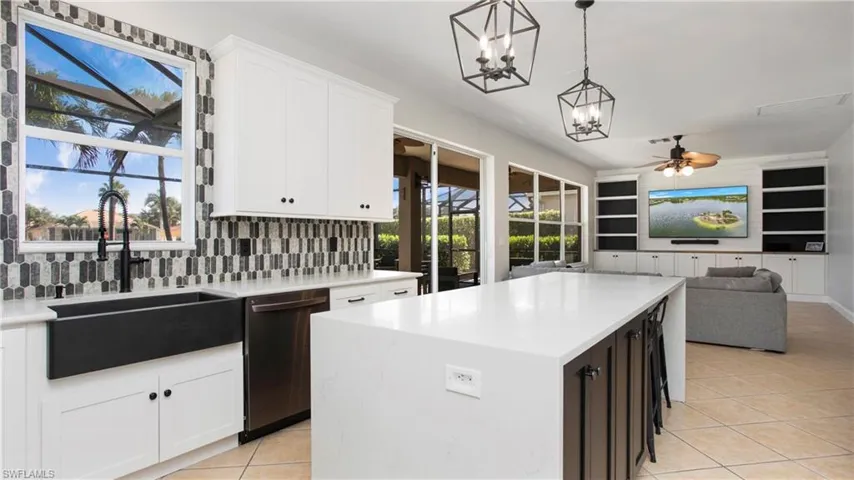 Kitchen with dishwasher, a chandelier, light tile patterned floors, and plenty of natural light