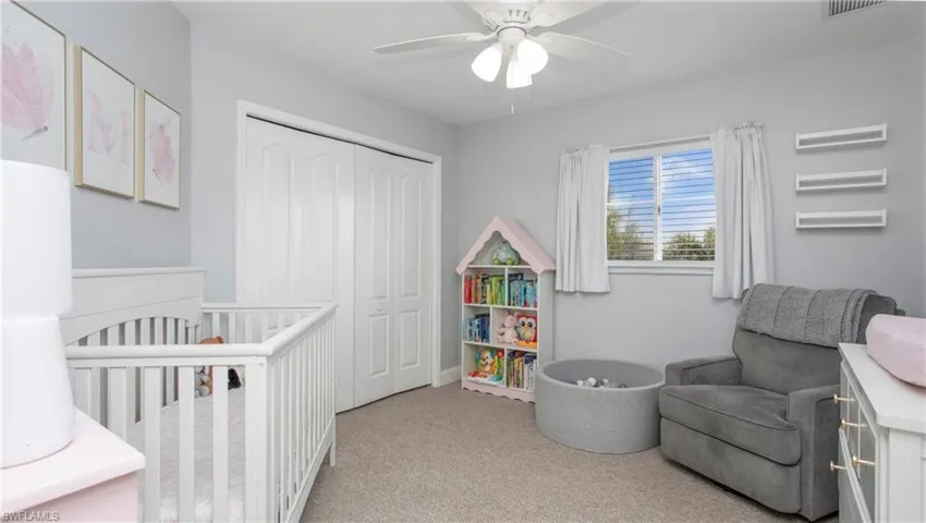 Bedroom featuring carpet flooring, a closet, a nursery area, and ceiling fan