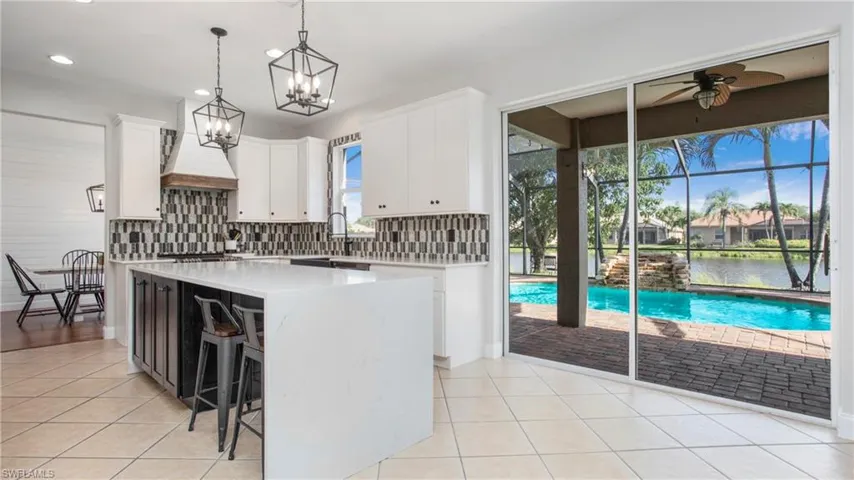 Kitchen with light countertops, light tile patterned floors, backsplash, and recessed lighting