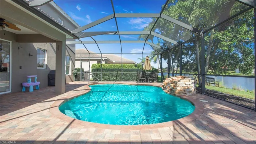View of pool with a patio area, a ceiling fan, and glass enclosure
