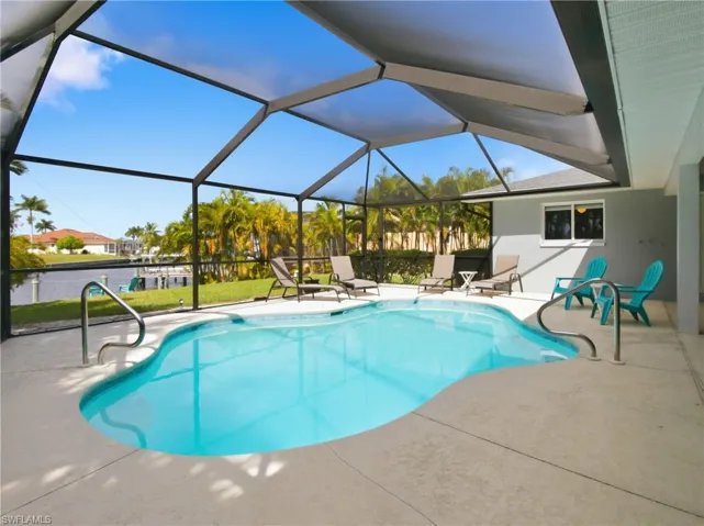 Swimming pool with a patio area, a sunroom, and a lanai