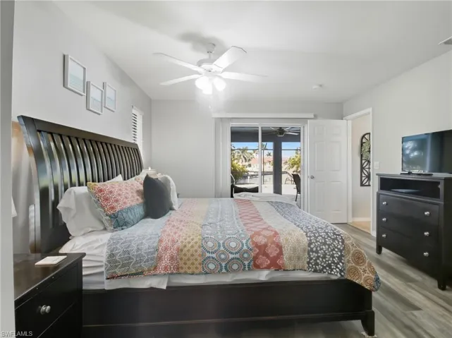 Bedroom featuring wood finished floors, access to exterior, and a ceiling fan