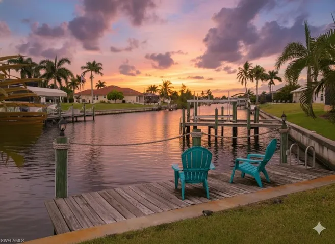 Dock area featuring boat lift, a water view, and a yard