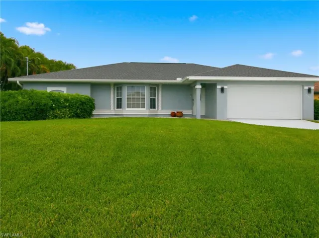 Ranch-style house featuring a front lawn, stucco siding, concrete driveway, a garage, and roof with shingles