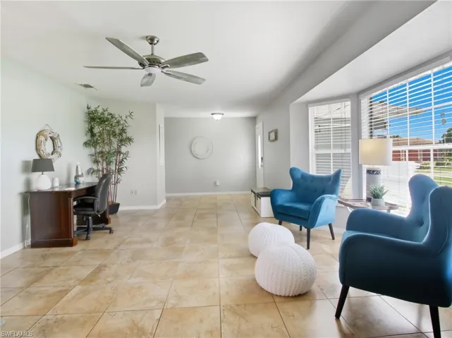Sitting room with an office area, a ceiling fan, and light tile patterned floors