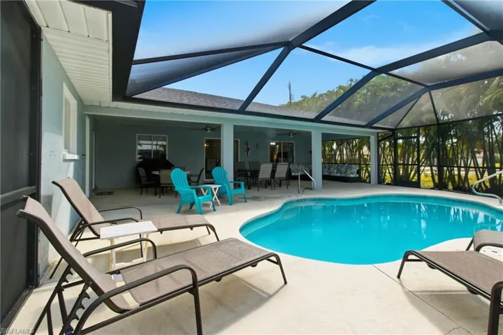 Swimming pool featuring a sunroom, a patio area, a lanai, a ceiling fan, and outdoor dining space
