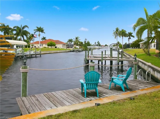 Dock with boat lift, a water view, and a residential view
