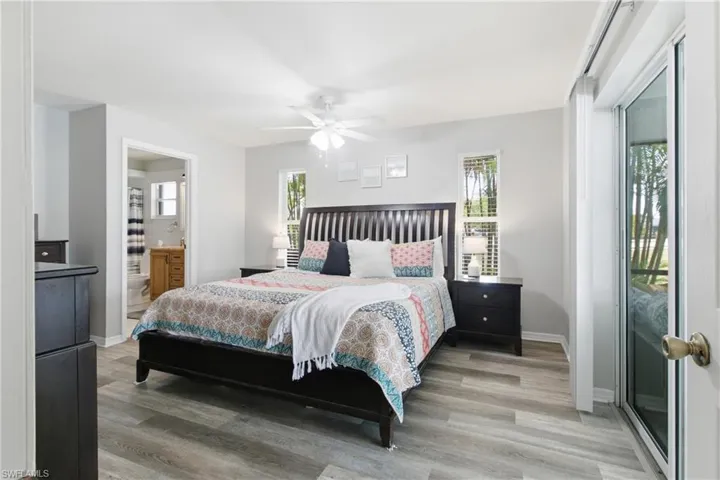 Bedroom featuring light wood-style flooring, ceiling fan, and connected bathroom