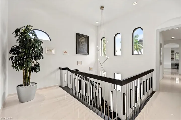 Hall featuring arched walkways and baseboards