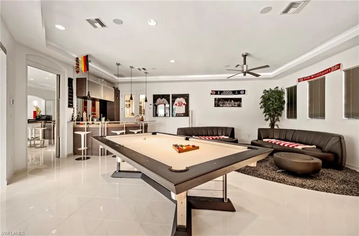 Game room with billiards, a raised ceiling, a ceiling fan, recessed lighting, and arched walkways