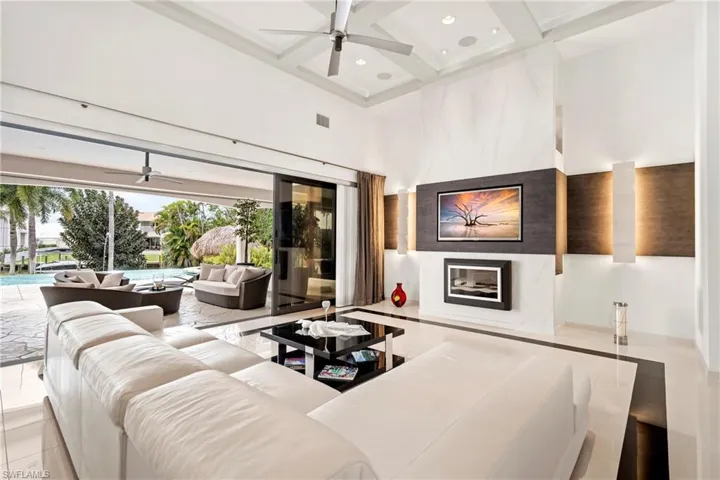 Living room with a ceiling fan, coffered ceiling, and recessed lighting