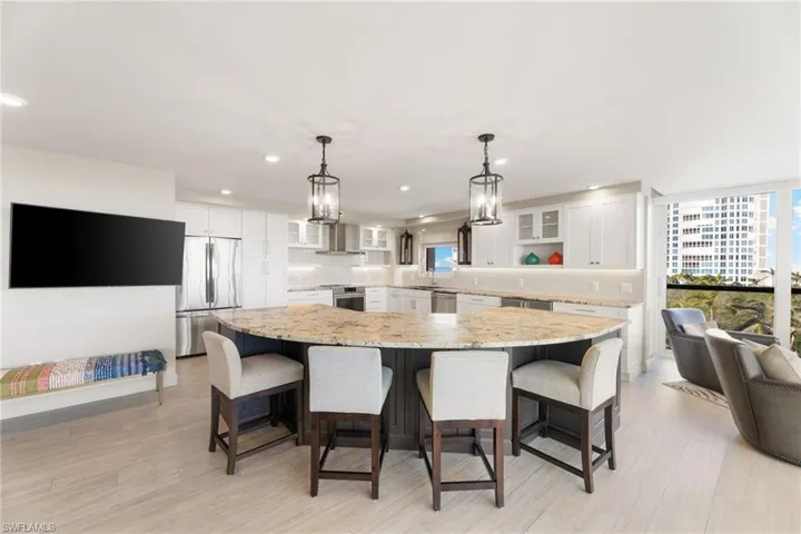 Kitchen with stainless steel appliances, white cabinetry, glass insert cabinets, tasteful backsplash, and a sink