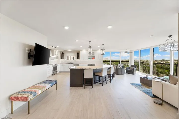 Living area featuring light wood-style flooring, recessed lighting, expansive windows, and a chandelier