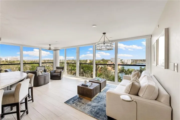 Living area with a chandelier, expansive windows, and light wood-style floors