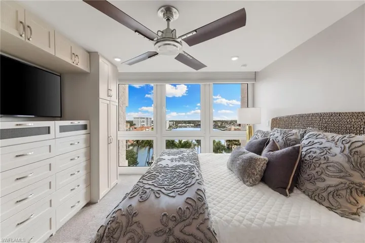 Bedroom featuring light colored carpet, multiple windows, ceiling fan, and recessed lighting