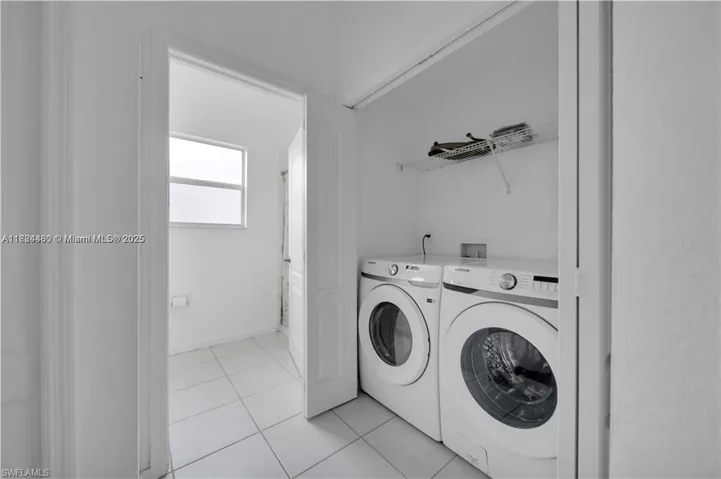 Laundry area featuring separate washer and dryer and light tile patterned floors