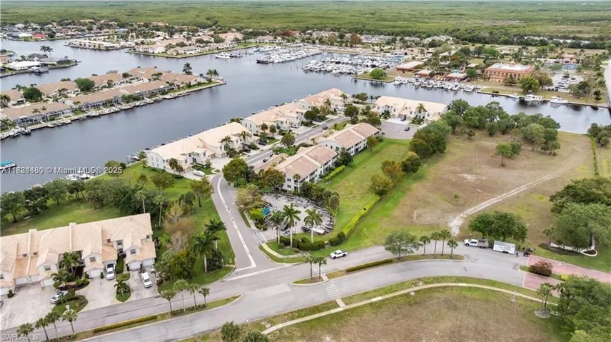 Aerial view of property's location featuring a nearby body of water and nearby suburban area
