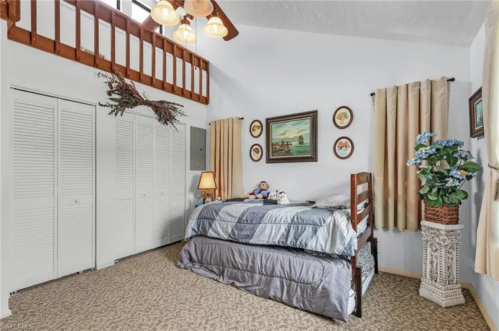 Carpeted bedroom featuring lofted ceiling and ceiling fan