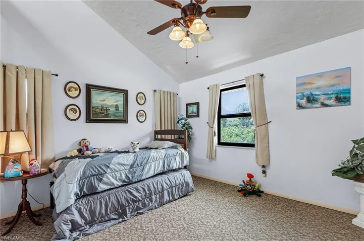 Bedroom featuring carpet flooring, ceiling fan, and vaulted ceiling