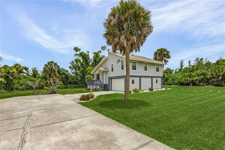 View of side of home featuring a garage and a yard