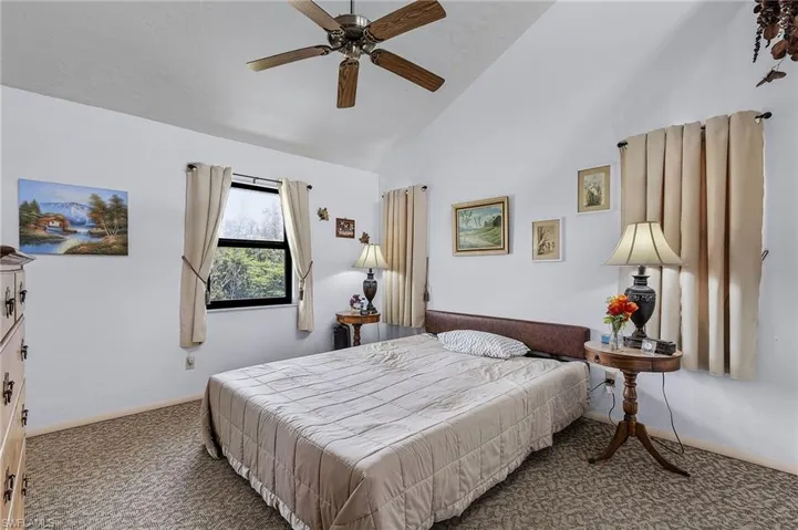 Bedroom featuring carpet, high vaulted ceiling, and ceiling fan