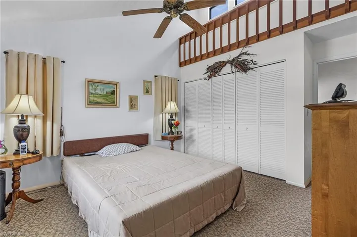 Bedroom with carpet floors, high vaulted ceiling, ceiling fan, and a closet