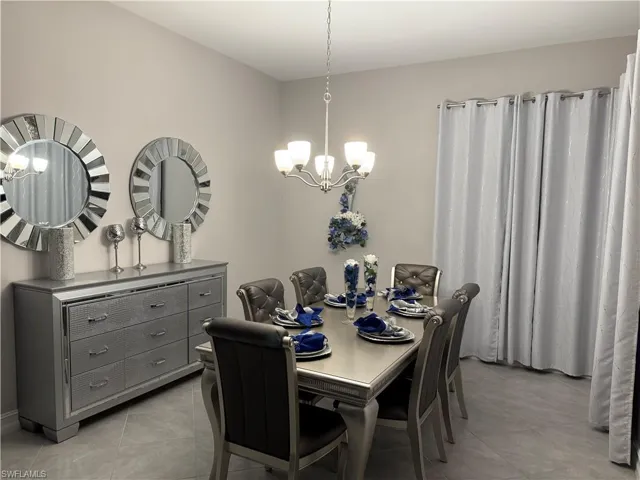 Dining room featuring light tile patterned floors and a chandelier
