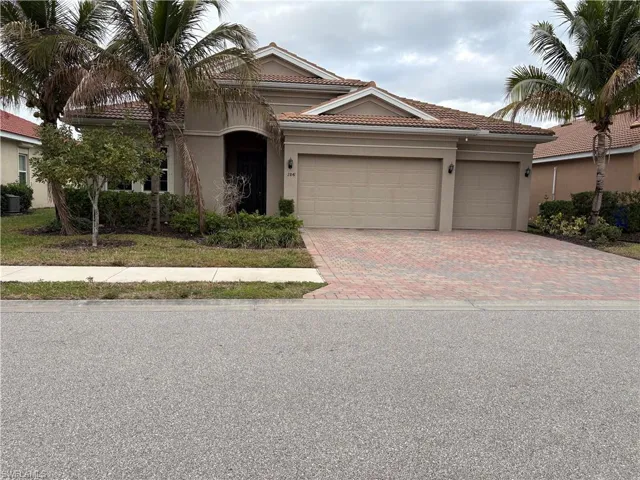 View of front of property featuring stucco siding, decorative driveway, a tiled roof, and a garage