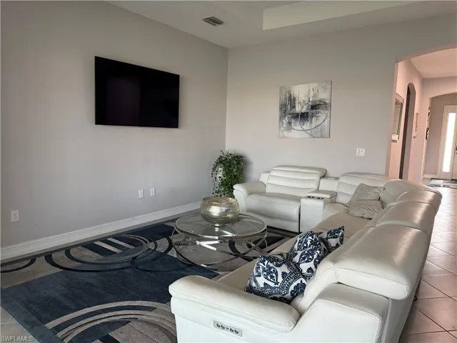 Living area with arched walkways and tile patterned floors