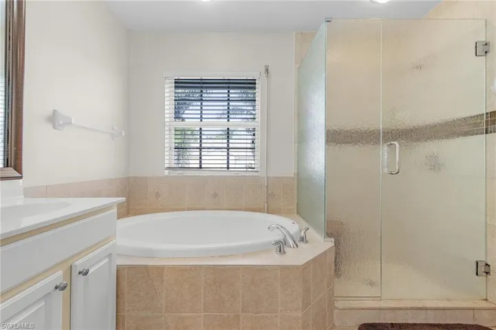 Bathroom featuring vanity and independent shower and bath