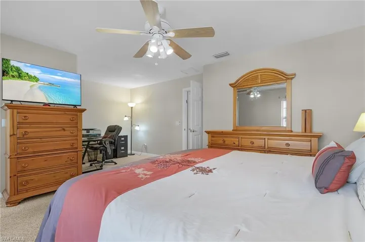 Carpeted bedroom featuring ceiling fan