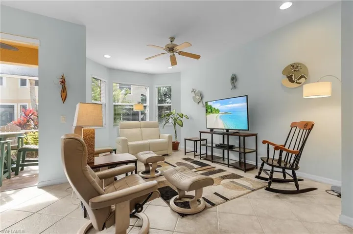 Living room with light tile patterned flooring and ceiling fan