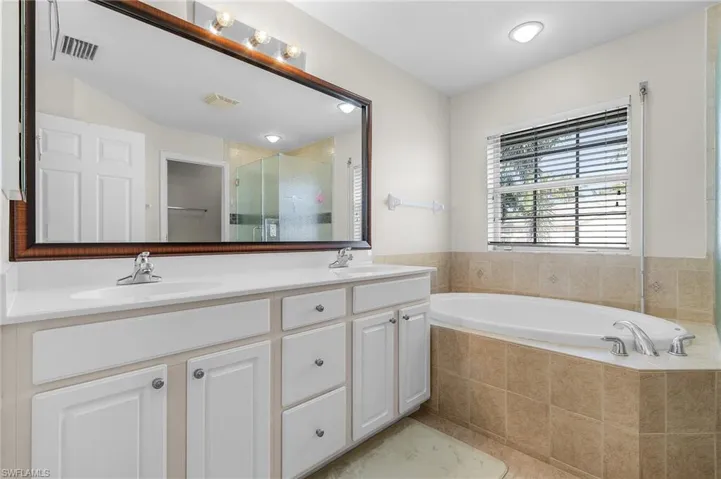 Bathroom featuring tile patterned floors, vanity, and independent shower and bath