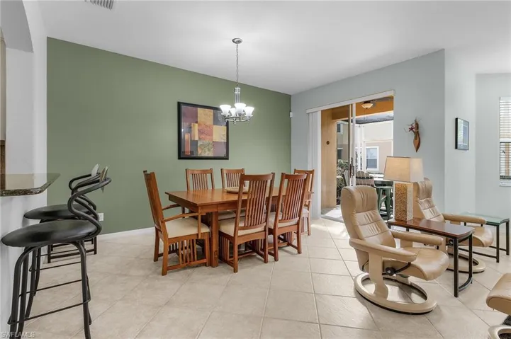 Dining area with an inviting chandelier and light tile patterned flooring