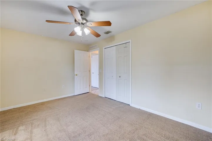 Unfurnished bedroom featuring carpet, ceiling fan, and a closet