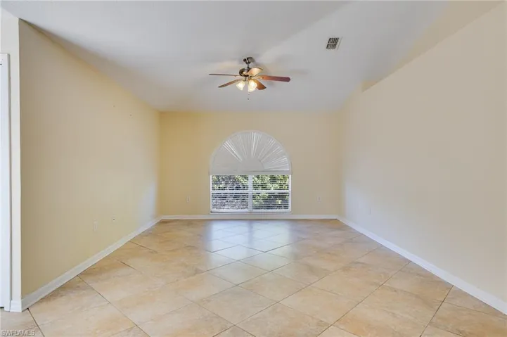 Empty room featuring ceiling fan and light tile patterned floors