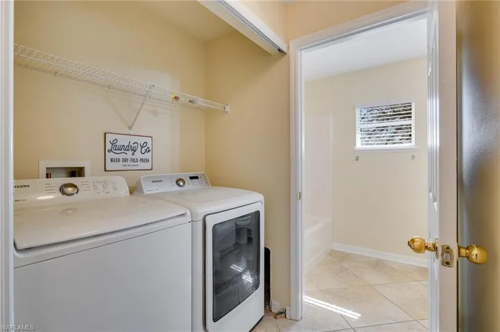 Laundry area featuring washer and dryer and light tile patterned floors