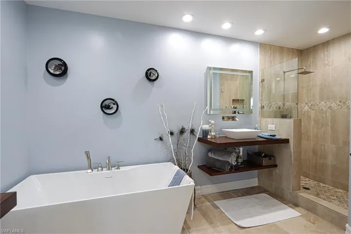 Bathroom with vanity, tile patterned floors, and separate shower and tub