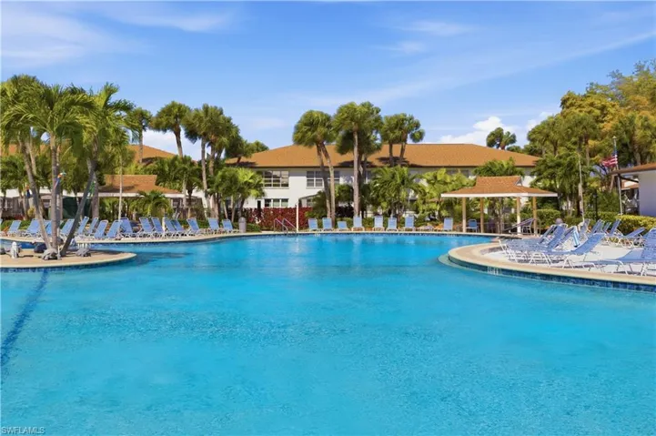 Expansive swimming pool with a curved edge and surrounding lounge chairs