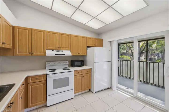 Kitchen featuring wood cabinetry, white countertops, a white electric range, and a white refrigerator