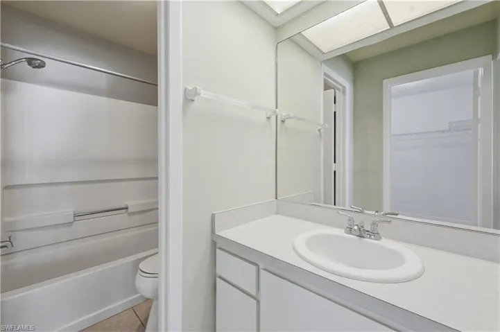 Bathroom featuring a vanity with an integrated sink, polished chrome faucet, and a large wall-mounted mirror